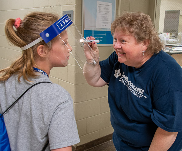 After practicing the same on SimMan, a high-fidelity manikin used in nursing coursework, a participant asks Betty Anne Leiby, simulation laboratory coordinator in nursing, to measure the dilation of her pupils.