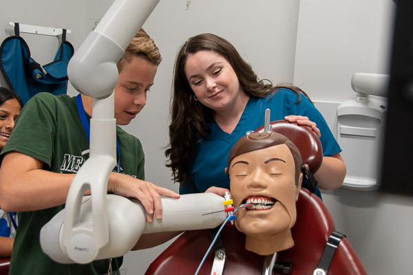 With guidance from dental hygiene student Jaclyn A. Wertz, of Loganton, a participant prepares to take a bitewing X-ray of Dexter (a DXTTR dental X-ray training manikin, that is).