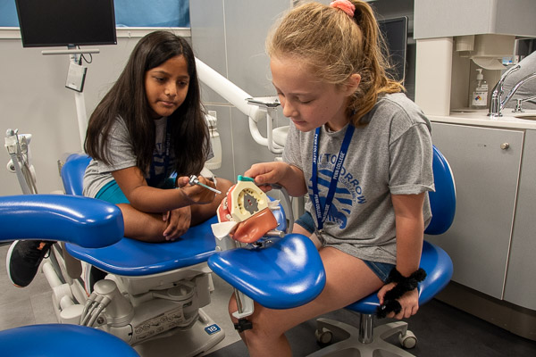 Girls get hands-on experience cleaning teeth.
