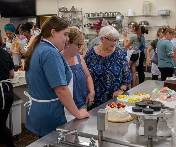 Families fill the baking lab to pick up their teenage cake stars – and their stunning work.