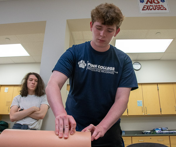 A participant practices a life-saving “stop the bleed” measure.