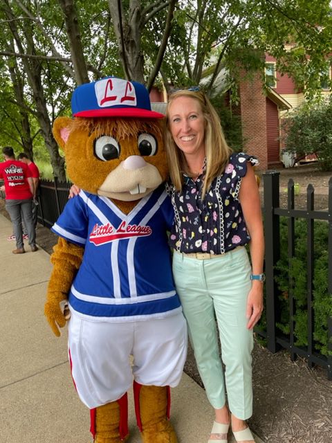 Dear friends – Dugout (Little League's Disney-created mascot) and Hillary E. Hofstrom, the college's vice president for people and culture – enjoy a reunion outside The Victorian House.