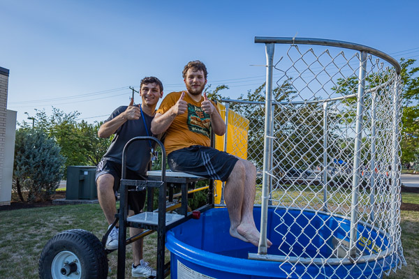 Representing Residence Life and gamely volunteering at the dunk tank are students Andrew C. Darling (left) and Frank A. Orzehoski.