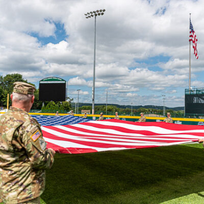 The stars and stripes are unfurled during a practice run at Volunteer Stadium.