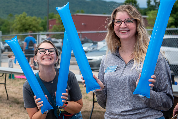 Kimberlee R. Rusczyk (left), manager of social media and online marketing, and Calli R. Ackels, wellness education coordinator, are all smiles and thunder sticks.