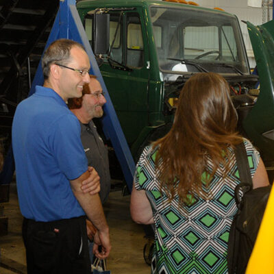Ford (in blue shirt) – who said he never dreamed of such an industry development when he was a student 20 years ago – talks with Mark E. Sones, one of his former diesel equipment technology instructors; and Shelley L. Moore, who, as senior director of the Center for Career Design, traveled to the ESC to greet the returning alumni.