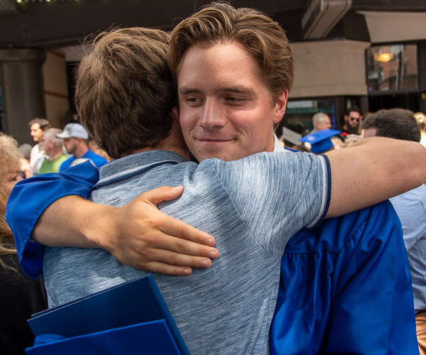 Building construction technology graduate Carson L. McChesney, of Bellefonte,  distributes hugs among his family members.