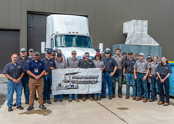 Mark E. Sones, instructor of diesel equipment technology (far left), and Greg Moser, district fleet manager for FedEx Freight and a 1999 alumnus (fourth from left), join with diesel students to commemorate FedEx Freight’s donation of a 2014 Kenworth T680 semi-trailer truck to Pennsylvania College of Technology to facilitate hands-on learning.