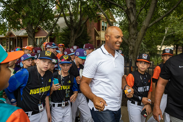 Little Leaguers surround Rivera on a campus stroll.