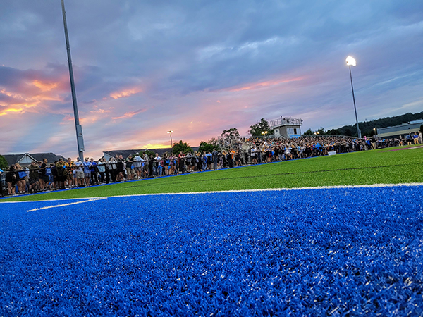 A field-level view catches Sunday's gorgeous sunset and the convocation participants amassed under it. (Photo by Kimberlee R. Rusczyk)