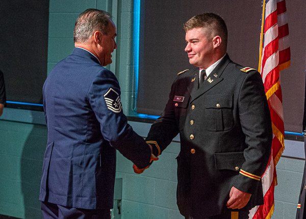 ... and shakes hands with his father, retired Master Sgt. Kurt (an Air Force veteran of Operation Desert Storm), after receiving his first salute.