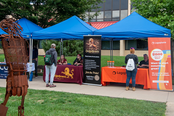 A perennially welcome addition to the colorful campus landscape is the sight of employers – in this case, The Lion Brewery (left) and Logoplaste USA – interacting with Penn College tomorrow makers.