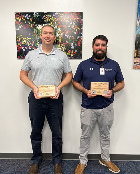 McAfee (left) and Coppadge display their awards for exceptional job performance.