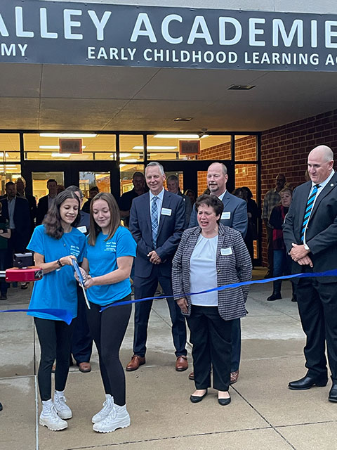 Students on the edge of success in the competitive 21st century job market cut the ribbon to officially launch the River Valley STEAM Academy in Indiana County. Helping to mark the occasion are (background, from left) President Reed; Connie Constantino, school board member; Rick Harper, board president; and Philip Martell, district superintendent.