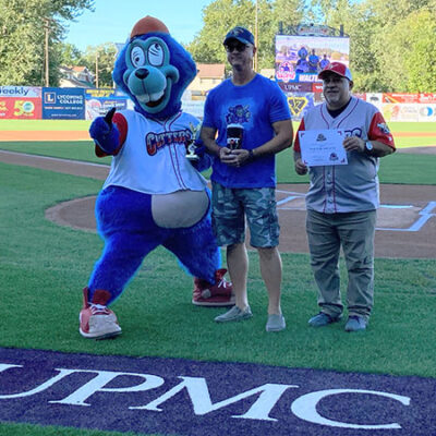 Shultz (center) is joined by Boomer, the team mascot, and Gabe Sinicropi, vice president of marketing. (Photo by Erin S. Shultz, career events manager and proud spouse)