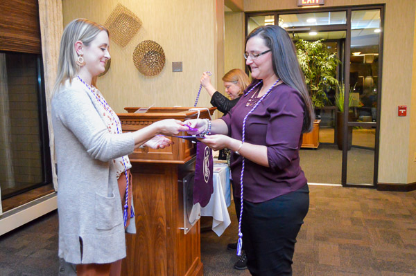 Sadie L. Folmar, instructor of nursing III, presents a certificate and other memorabilia to new inductee Caroline N. Green, of Picture Rocks.