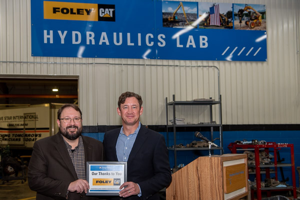 Rebranded as the Foley Hydraulics Lab, instructional space at the Schneebeli Earth Science Center serves as a backdrop for a commemorative photo with Justin W. Beishline (left), Penn College's assistant dean of diesel technology and natural resources; and Jamie Foley, Foley Inc.'s chief executive officer.