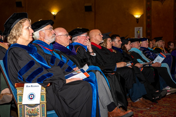 Members of the board of directors, joined by visiting college and university delegates, fill the front row.