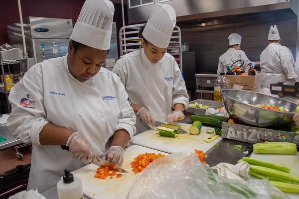 Hart (left) and Acosta chop some of the fresh vegetables available through the Food Bank for use in the ratatouille.