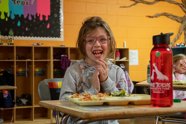An after-schooler is excited – but for the food or the camera?