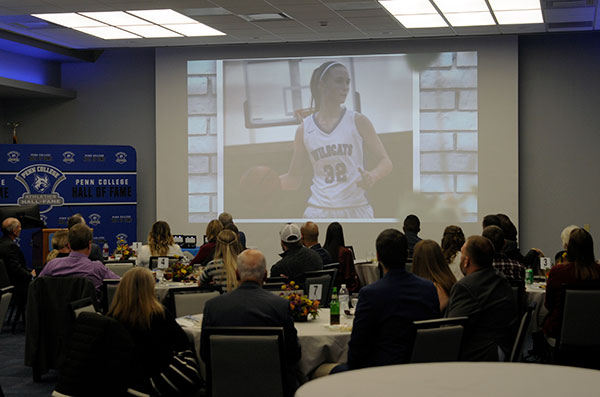 The Thompson Professional Development Center audience watches highlights of each Hall of Fame inductee's Penn College athletic career. Attendees also heard about the Wildcat Club, membership of which has quickly grown to 320 members. Several higher-level donors were present: President Reed, and Elliott and Carolyn Strickland (Coach's Level); and Timothy and Tiffany Rissel, Timothy and Christine Weigle, and Tom and June Kilgus Zimmerman (Captain's Level).
