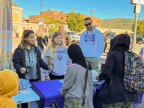 Students Emily Smith, Selena A. Martinez and Chance Moore talk with guests at the UPMC Community Block Party, in the parking lot outside of Liberty Arena.