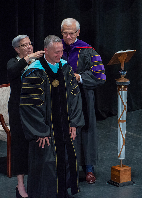 President Emeritus Davie Jane Gilmour, assisted by Board of Directors Chair Sen. Gene Yaw, presents the Presidential Medallion to new Pennsylvania College of Technology President Michael J. Reed during an Oct. 21 inauguration ceremony at the college’s Community Arts Center, Williamsport.