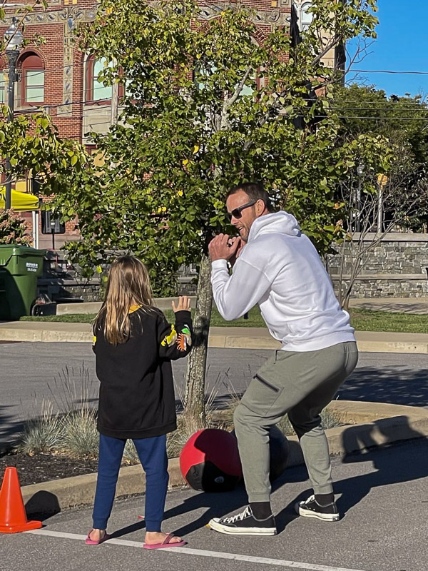 Moore guides a youngster through a power-squat station at the community block party.