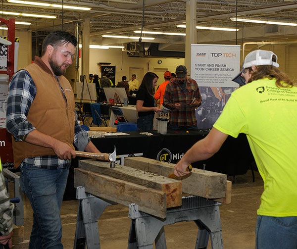 A T-Ross Brothers Construction Inc. employee encourages a hammer-wielding visitor to the Milton firm's nail-pounding challenge.