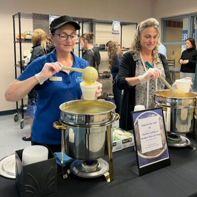 Denise M. Gardner-Butler (left), dining services worker, and Carla J. Douty, dining services purchasing assistant, serve up a choice of chicken tortilla or cheddar broccoli soup outside Wildcat Express.