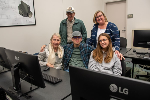 Engineering CAD technology student Cameron Musser (center), of Gilbertsville, gives his family a lesson on design in an engineering design technology lab. He is joined by his grandparents Barb and Bud Baldwin, sister Grace and mother, Brooke.