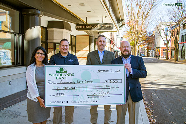 Acknowledging a $5,000 donation outside the Community Arts Center are (from left) Ana Gonzalez-White, college relations officer, CAC; Matt Gottschall, community office manager, Woodlands Bank; Jim Dougherty, the arts center's executive director; and Jon Conklin, Woodlands' president and CEO.