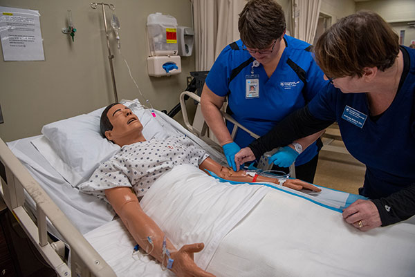 Pennsylvania College of Technology nursing student Johnette A. Michaels (left), of Danville, practices IV insertion alongside Ann E. Morrison, instructor of nursing. Penn College recently announced that it will no longer require the Test of Essential Academic Skills as part of the criteria for selective admission into its nursing majors. 