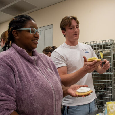 Monique C. Anderson-Parker, a human services & restorative justice student from Williamsport, and Dominic L. Valentine, an aviation maintenance technology student from Brockton, spread a base layer onto their sugar cookies.
