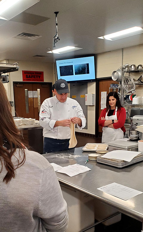 Victoria Hurwitz, director of the college's physical therapist assistant program, intently watches Chef Todd M. Keeley, assistant professor of baking and pastry arts/culinary arts ...