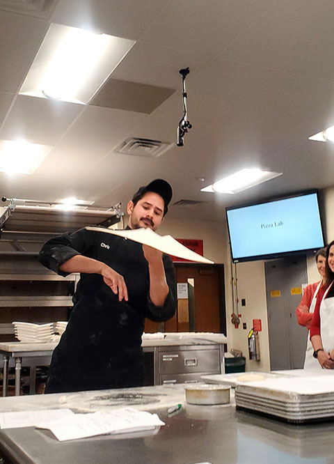 Putting his skills on display is Christopher R. Kelley, a dining services leader (and dough-stretcher extraordinaire).