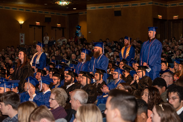 Enveloped by extended applause that rightfully echoes from commencement to commencement, graduating veterans rise to be acknowledged by an appreciative audience. 