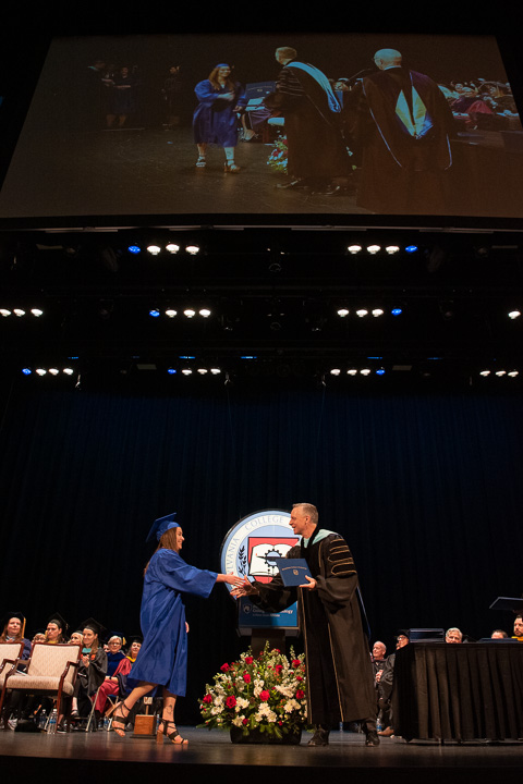 Under blue and white lights that add a holiday sparkle, Cassidy S. Thomas picks up her associate degree in nursing.