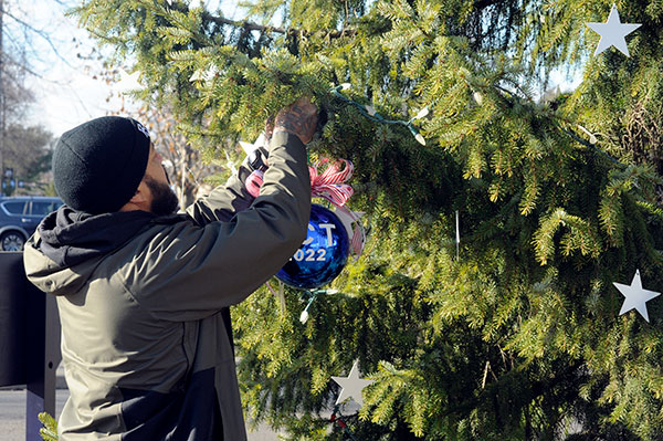 A pre-physician assistant studies student and 18-year veteran, including deployments to Iraq and Afghanistan, Jones hangs the newest ornament on the Veterans Holiday Tree. The ball contains ribbons sold to benefit The Fisher House Foundation, best known for a network of comfort homes where families of wounded veterans can stay at no cost while their loved ones are receiving treatment. 