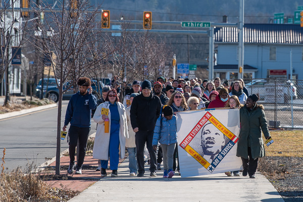 The marchers make their way up Basin Street toward Lycoming College. (STEP AmeriCorps manager Carrie Campbell Bruning is in sunglasses at center, behind the banner.)