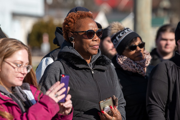 Capturing illumination in the sunshine, participants listen to Sophia Stabley, director of community service and involvement at Lycoming College, during one of the stops along their 1-mile loop.