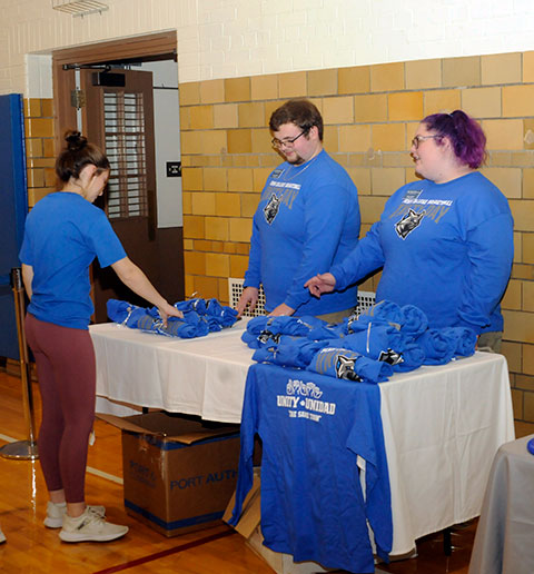 Event assistants Kellor A. Schooley and Maya A. Lawton handily handle the T-shirt table near the entrance to the gym ...