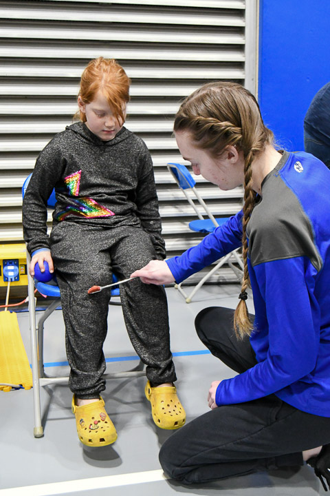 Kayleann Finan, a physical therapist assistant student from Watsontown, checks a youngster's reflexes.