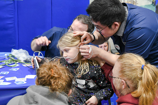 At the physician assistant studies table, Ryan Y. Park, of Newcastle, Wash., puts a camera into a child's ear, allowing her to assess the view on a handheld screen. Partially visible in the background is PA classmate Phillip J. Silvagni, of Williamsport.