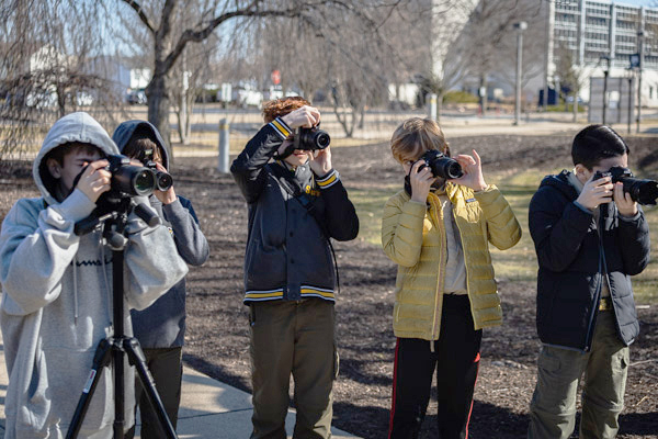 Scouts assess the world through the viewfinders on their digital cameras during a photography session with Mark W. Wilson, graphic design instructor.