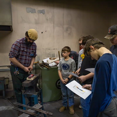 Daniel Ravizza, instructor of CNC machining/automation, keeps the Scouts in thrall during their productive lab visit.