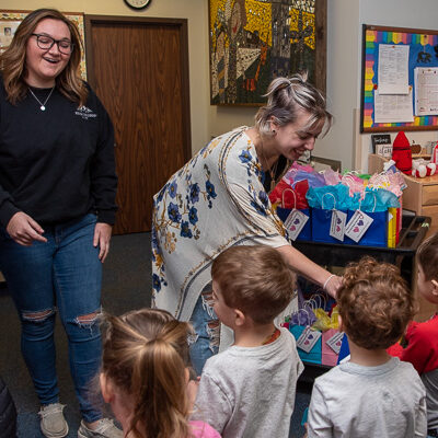 With the delight evident on their faces, PTK chapter president Christine A. Limbert (left) and secretary Cheyenne E. Stein distribute gift bags to a line-up of “Bears” (the classroom name for children ages 3 and 4). 