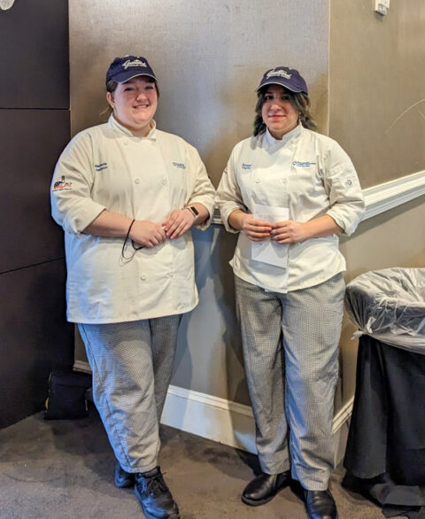 Penn College baking & pastry arts students M.J. Harbron (left), of Pottstown, and Amber R. Harris, of Sciota, pause for a photo between helping presenters at the two-day conference,