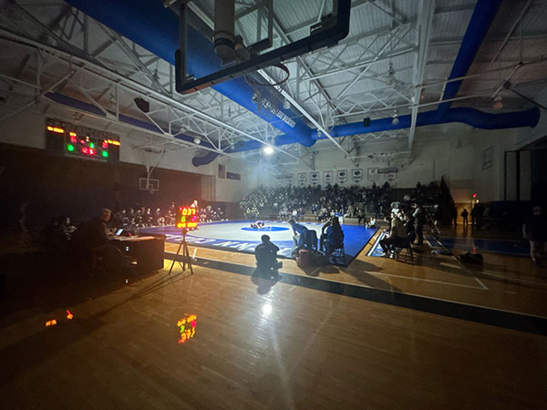 Subdued lighting centers the action on the mat during Friday's final home match of the regular season. (Photo by Frank T. Kocsis III, student photographer)