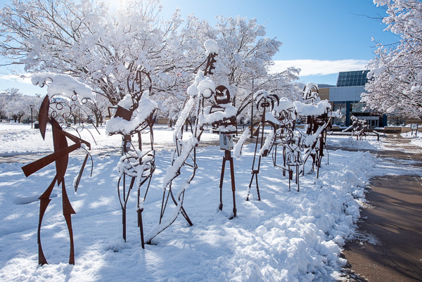 With no students on campus due to Spring Break, the welded Student Bodies sculptures substitute as “mall walkers.”